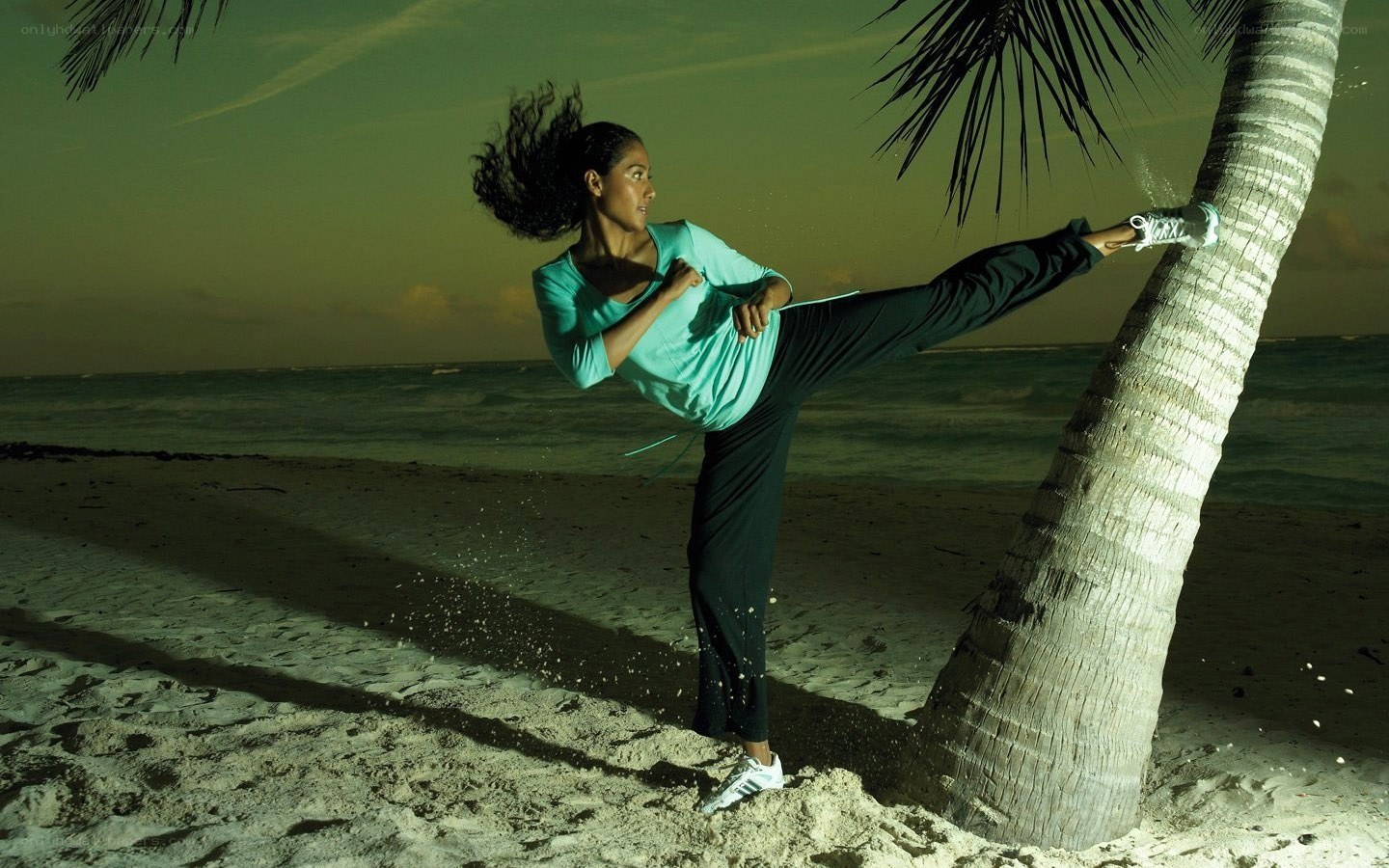 Woman doing kick on beach