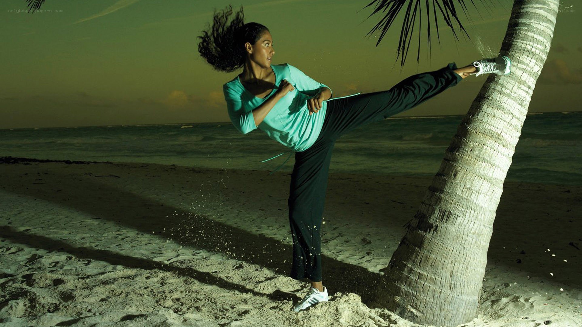 woman doing kick on beach