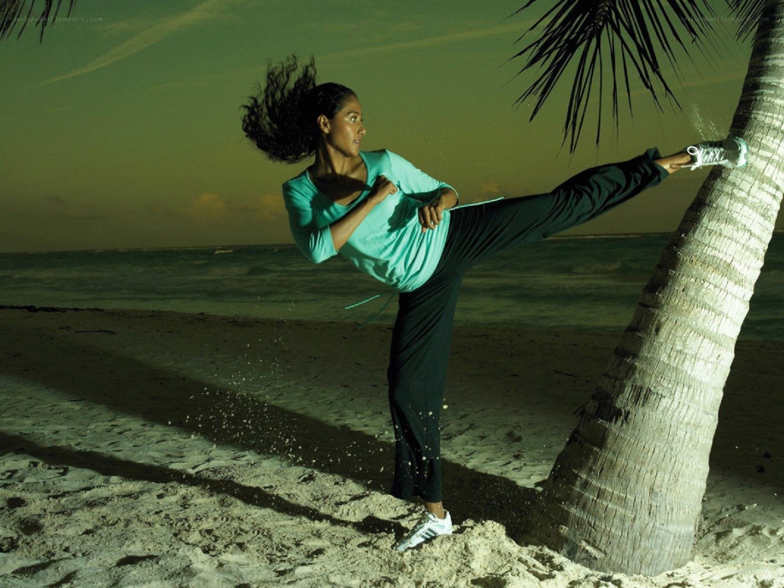 Woman doing kick on beach