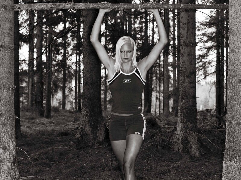 woman doing pull-ups in forest