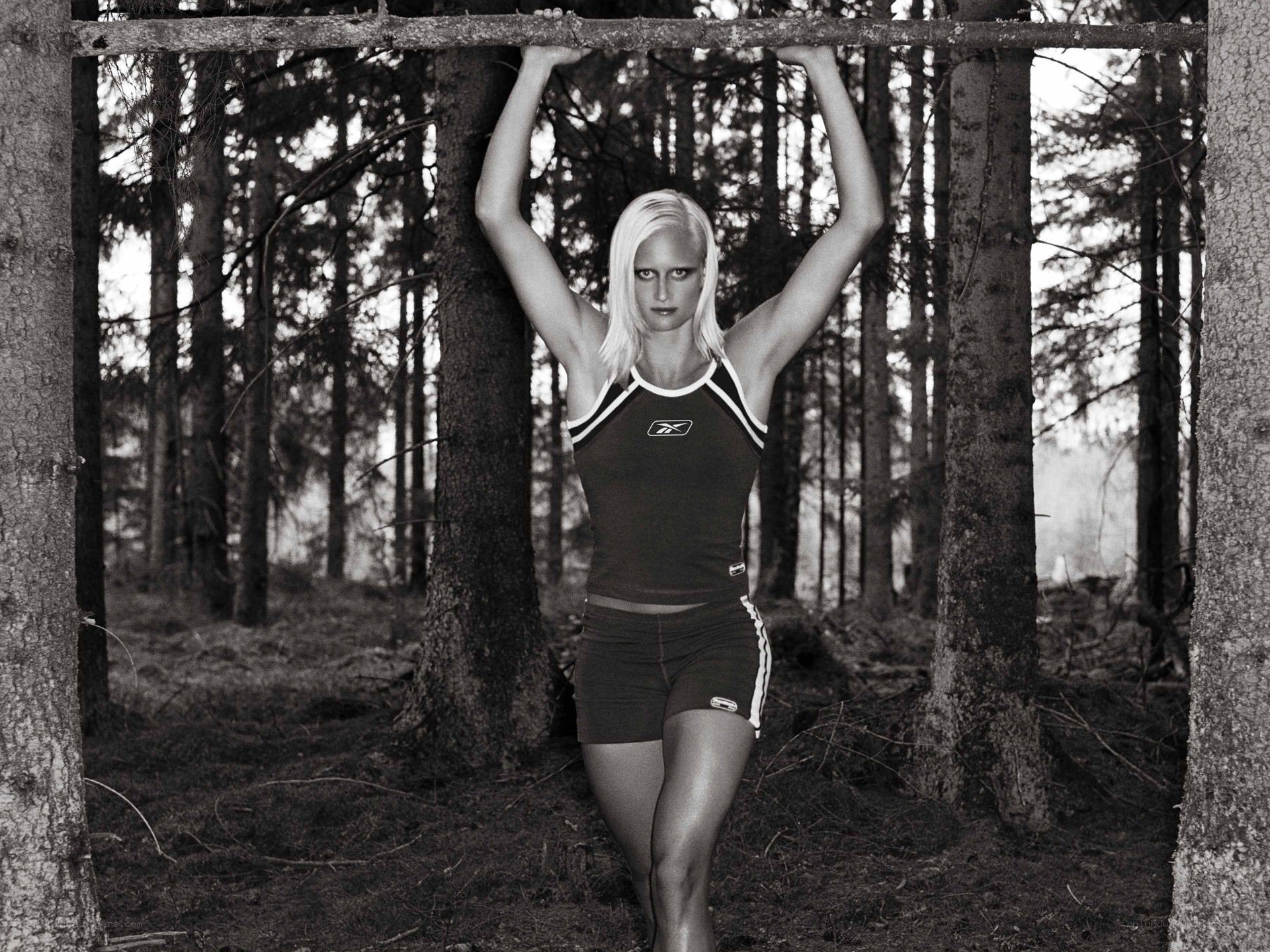 woman doing pull-ups in forest