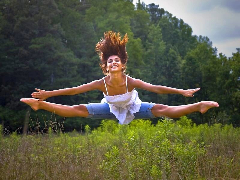 woman doing split in field