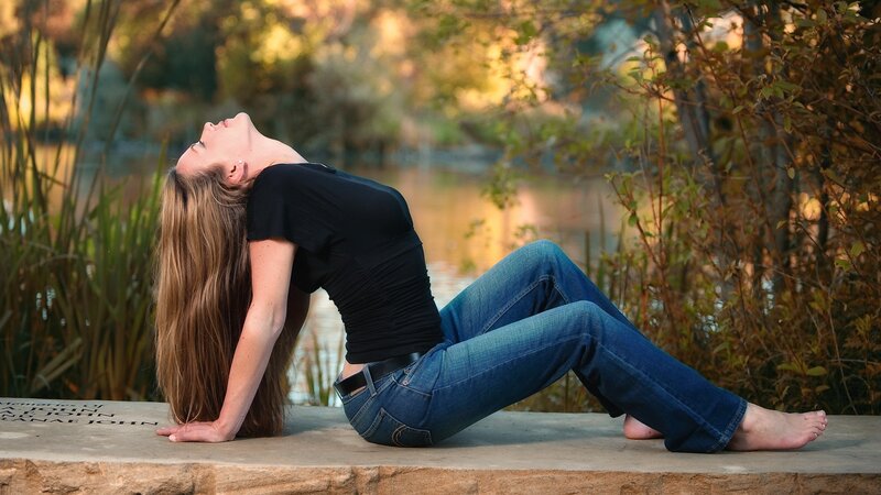 woman doing yoga by a pond