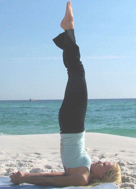 woman doing yoga on beach