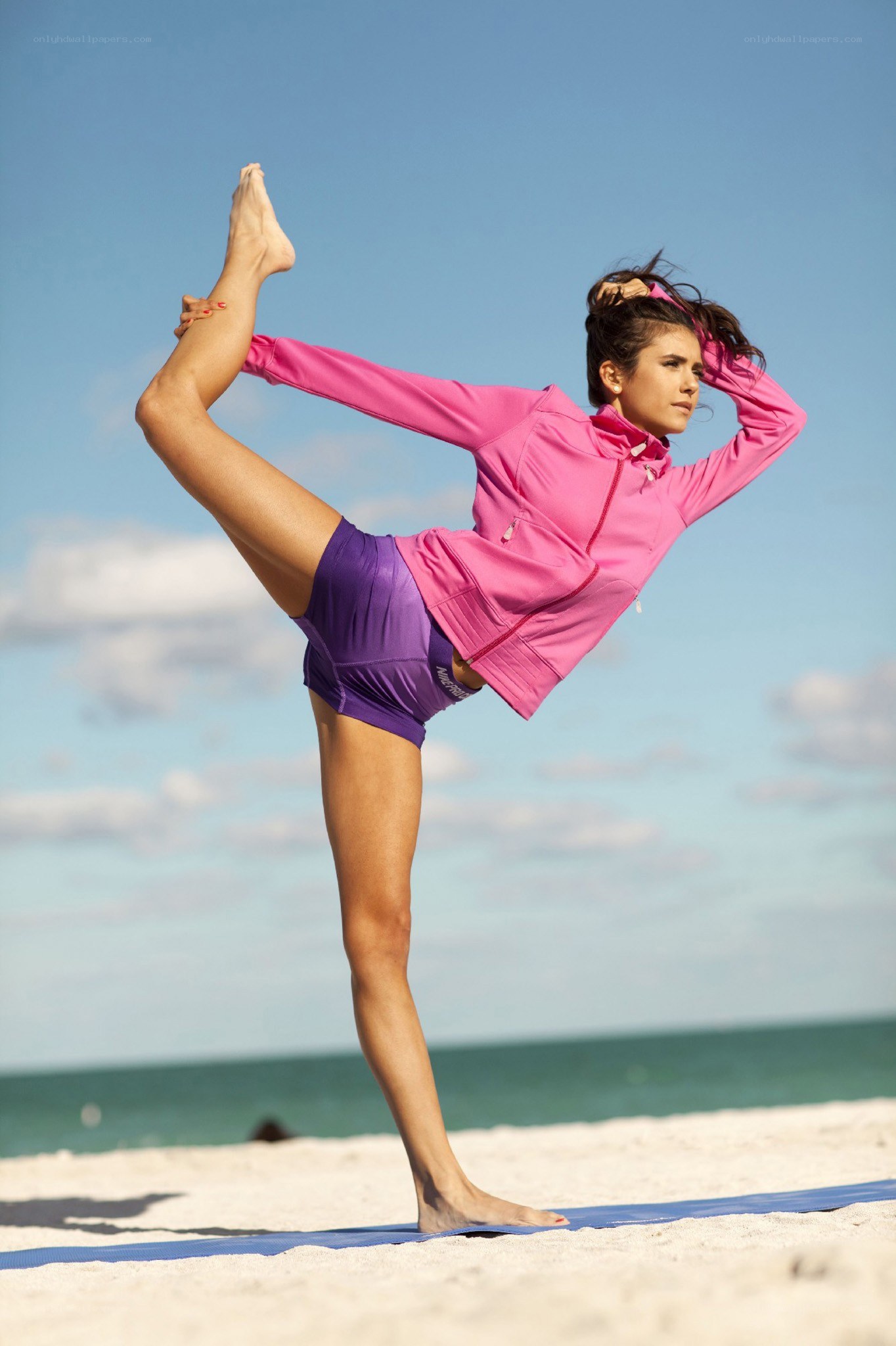 woman doing yoga on beach
