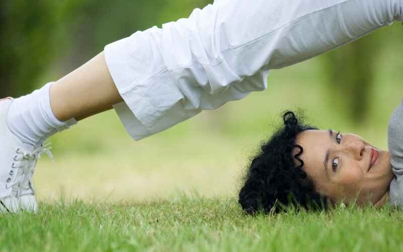 woman doing yoga on grass