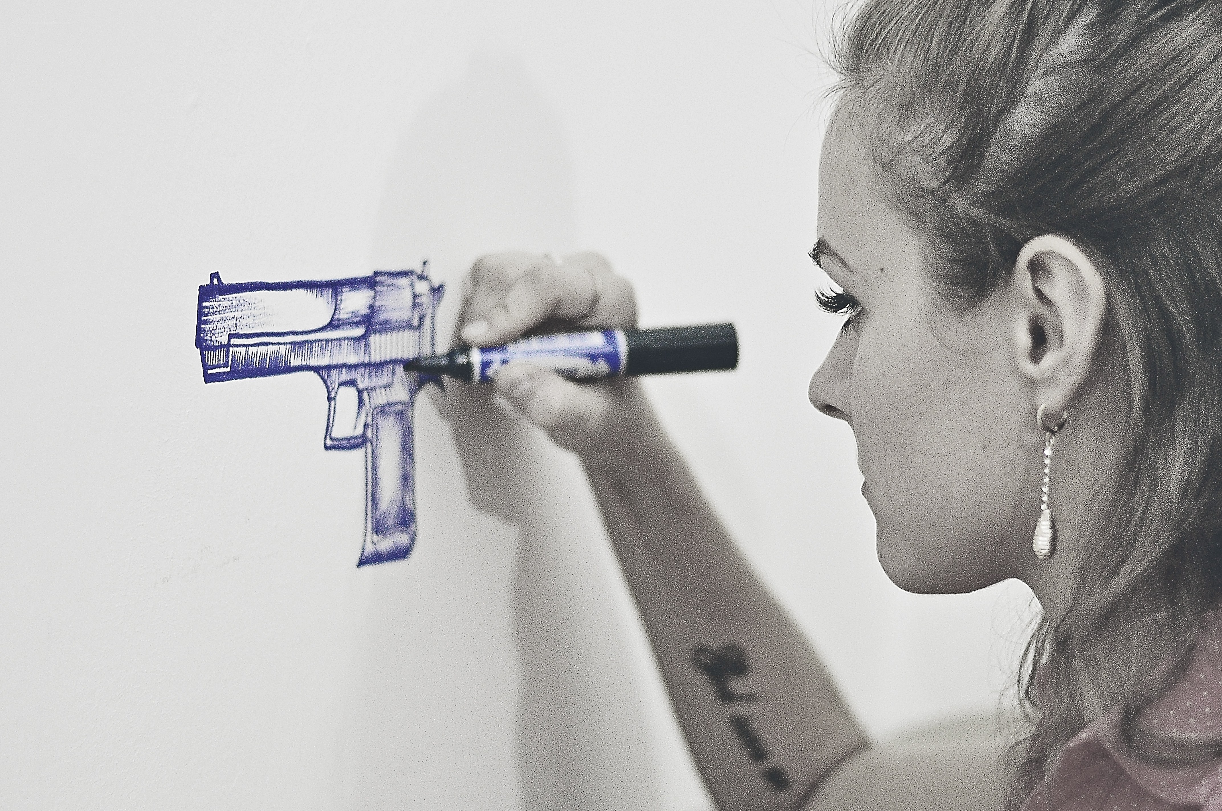 woman drawing gun on wall