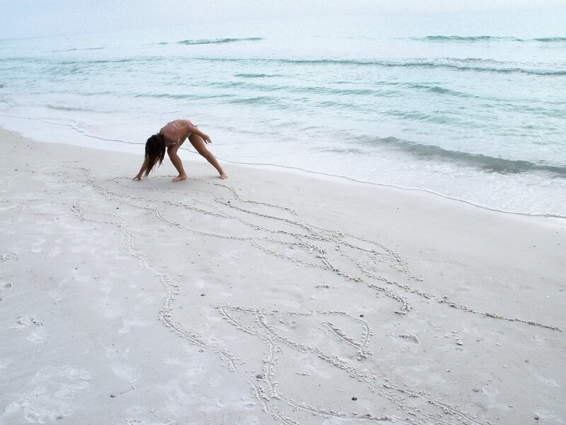 Woman drawing in the sand