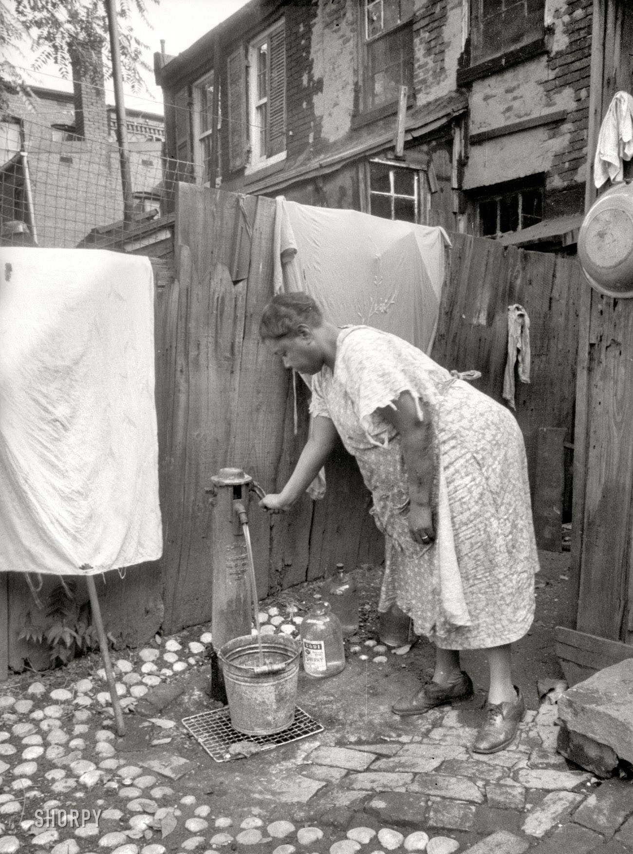 Woman drawing water from a pump