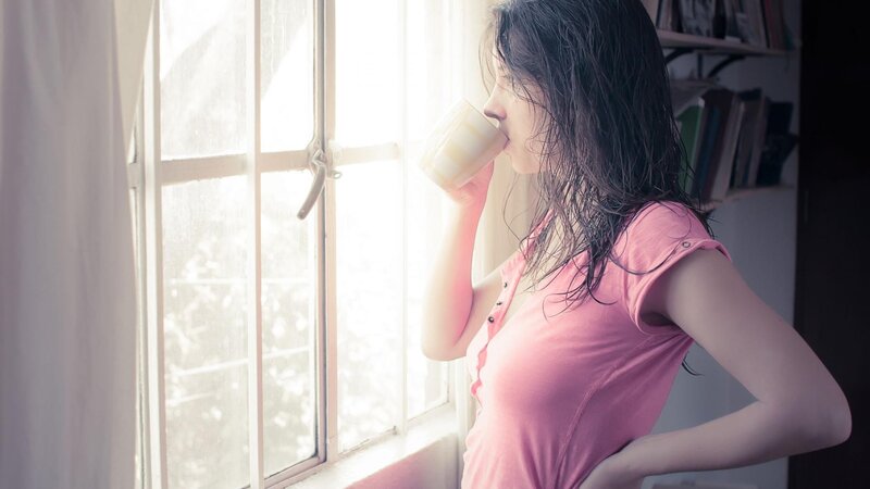 woman drinking by window