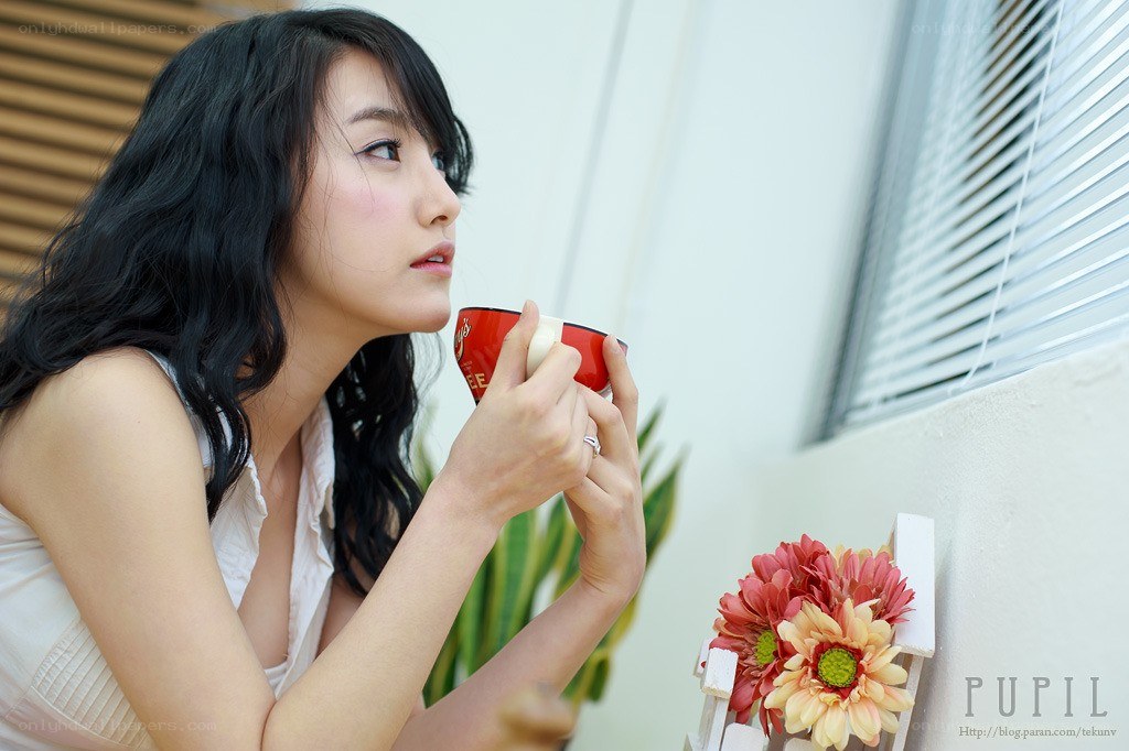 woman drinking coffee by window
