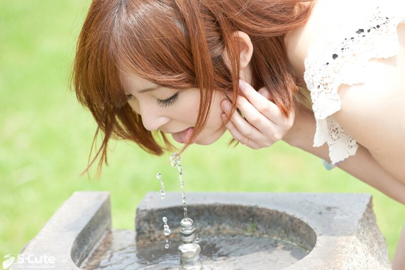 woman drinking from a fountain