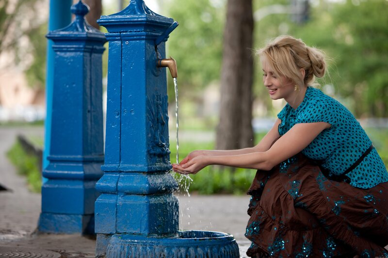 woman drinking from a fountain