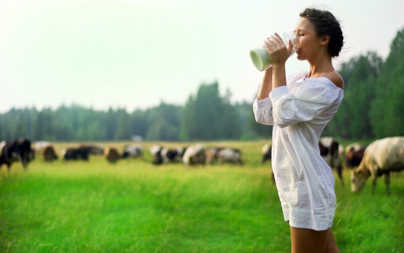 woman drinking milk in field