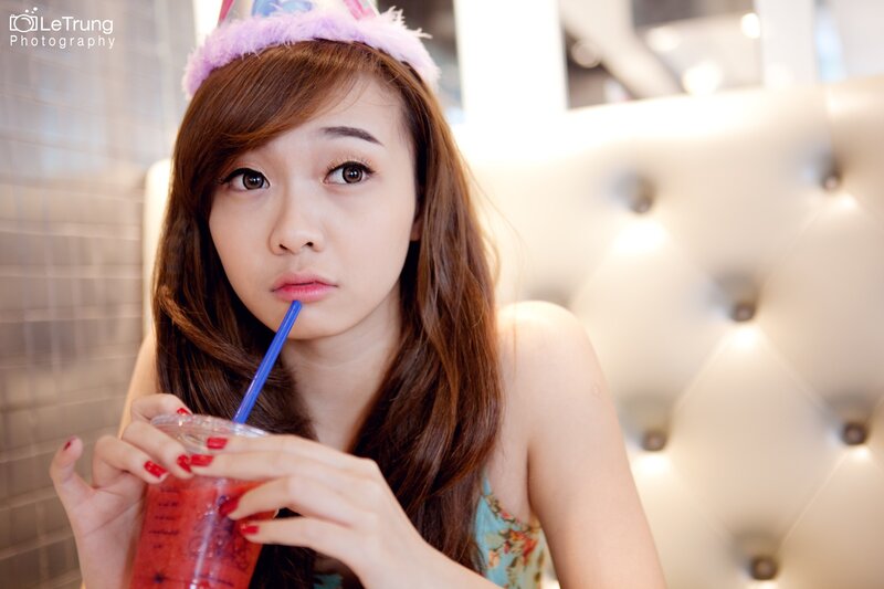 woman drinking smoothie with party hat