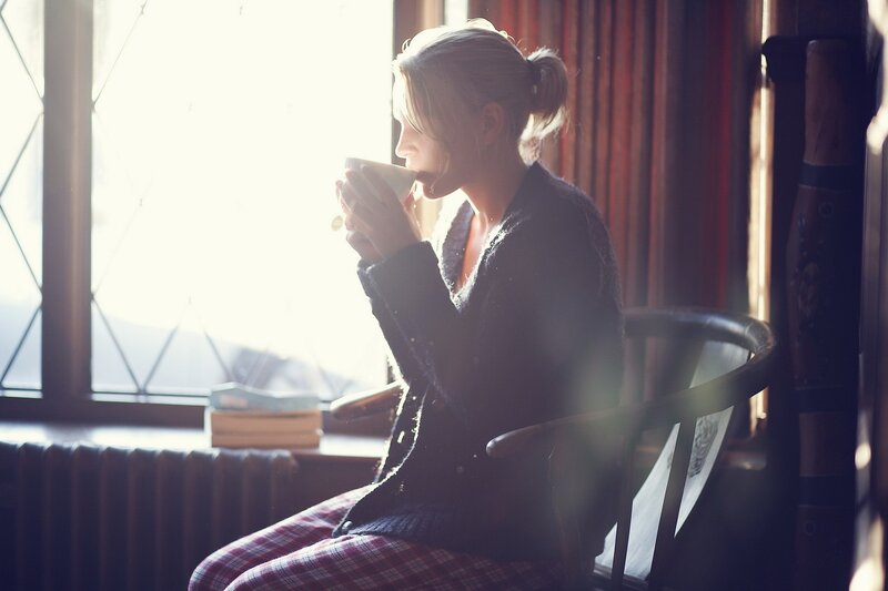 woman drinking tea by window