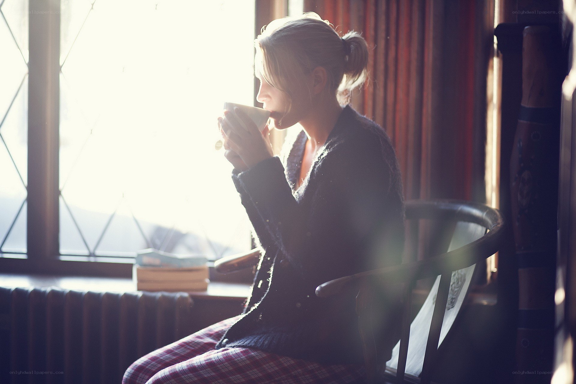 woman drinking tea by window
