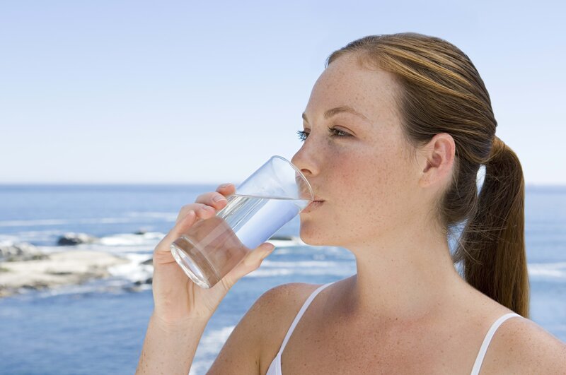 woman drinking water by the sea