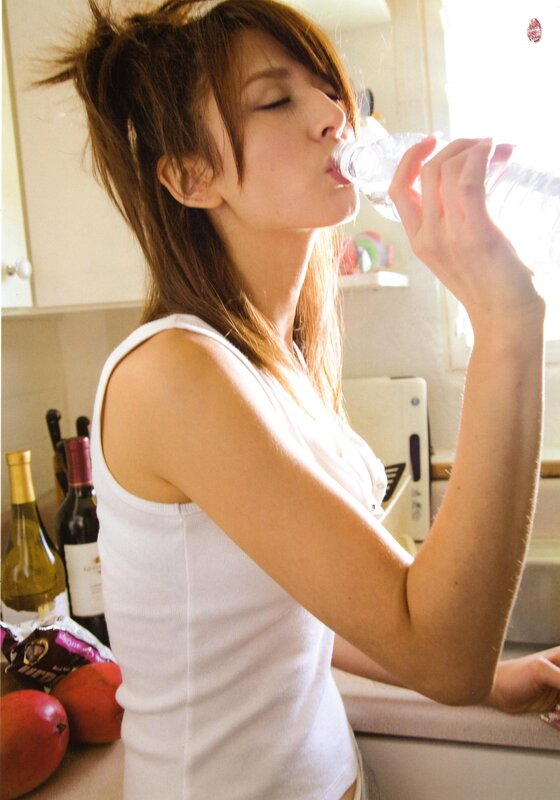 woman drinking water in kitchen