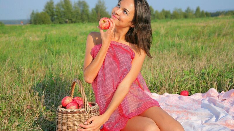 Woman eating apple in field