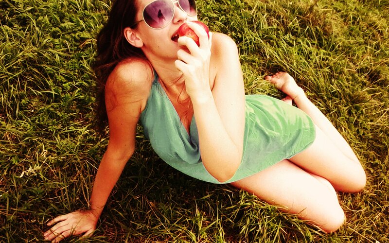 Woman eating apple in grass
