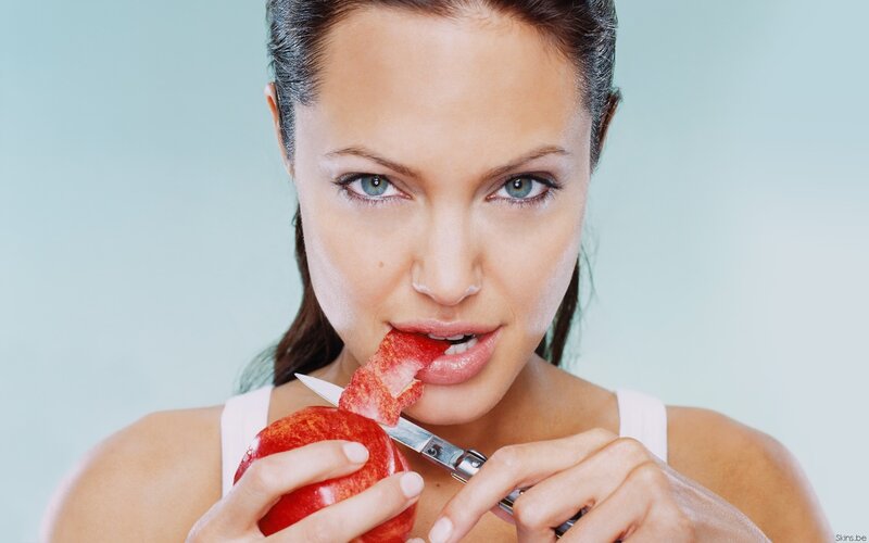 woman eating apple with knife