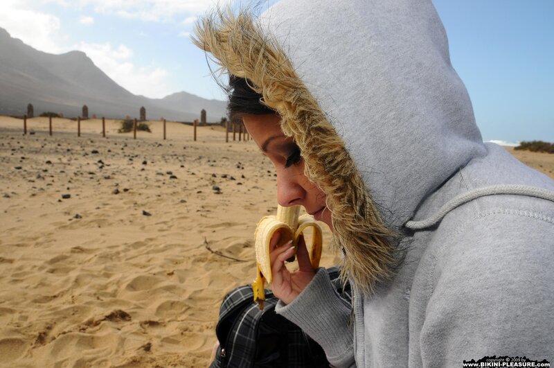 woman eating banana on beach