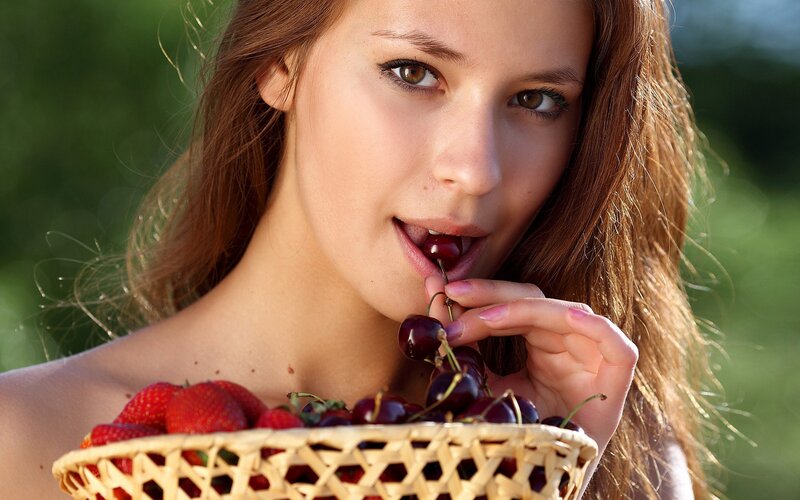 woman eating cherries outdoors