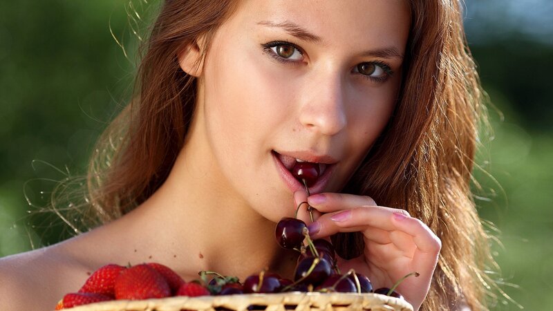 woman eating cherries outdoors