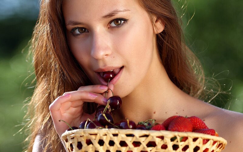 woman eating cherries outdoors