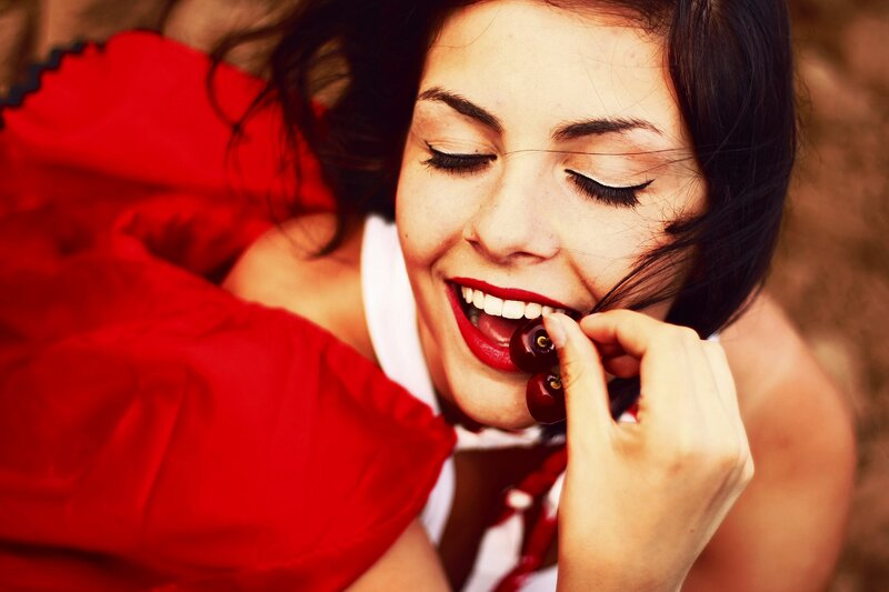 Woman Eating Cherries — Red, Playful