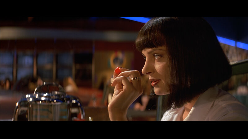 woman eating cherry in diner