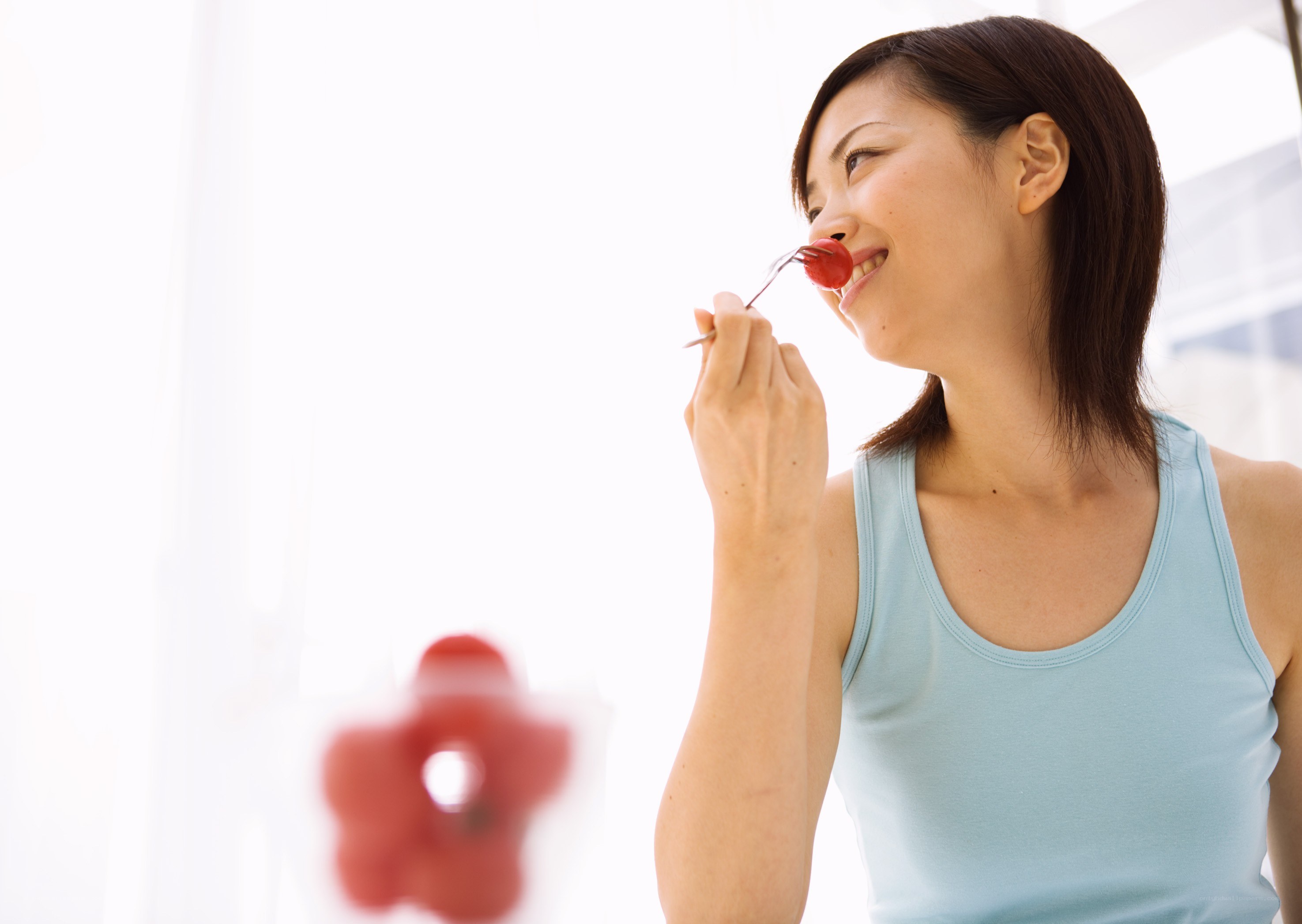 woman eating cherry with fork