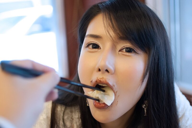 woman eating dumpling with chopsticks