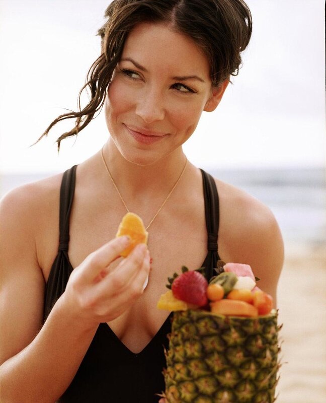 woman eating fruit at beach