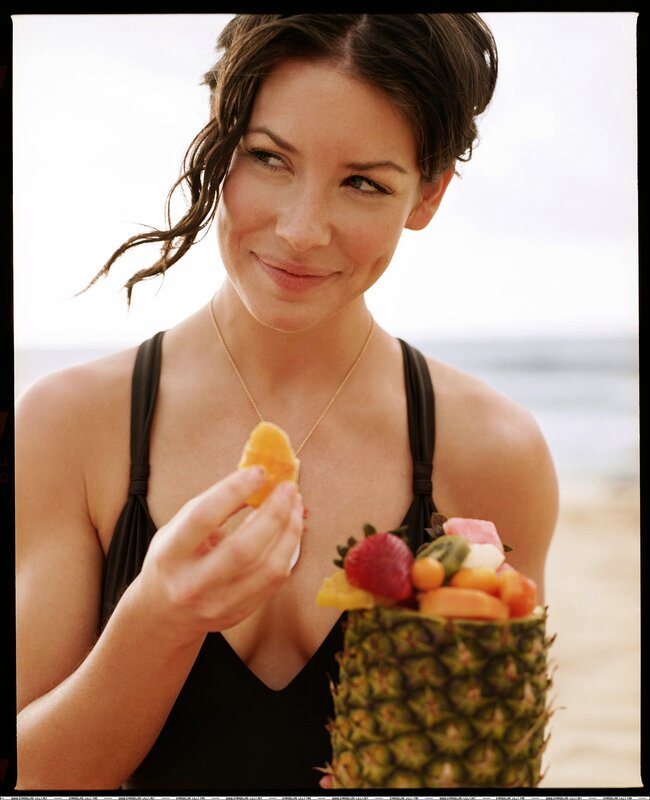 woman eating fruit at beach