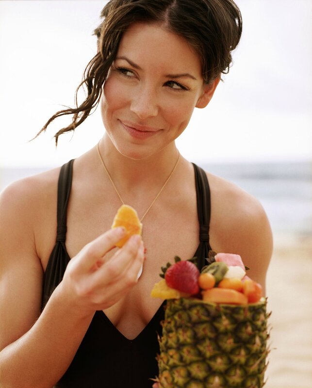 woman eating fruit at beach