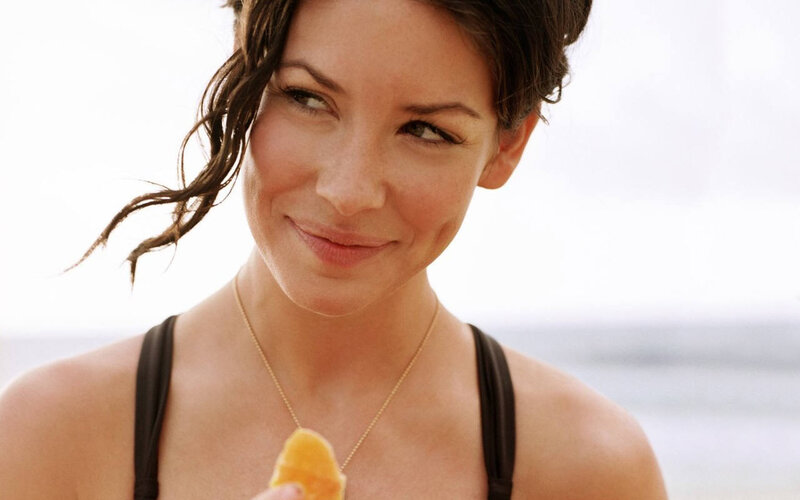 woman eating fruit at beach