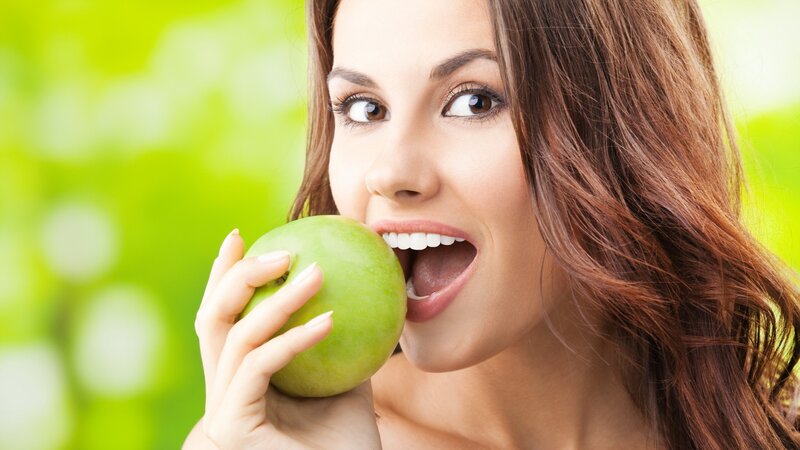 woman eating green apple