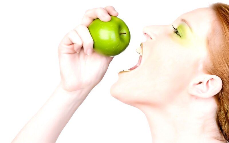 woman eating green apple