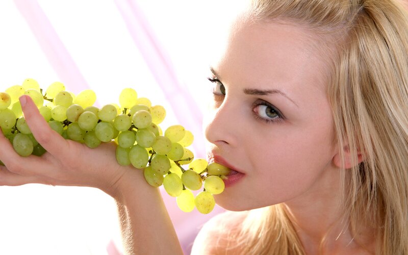 woman eating green grapes