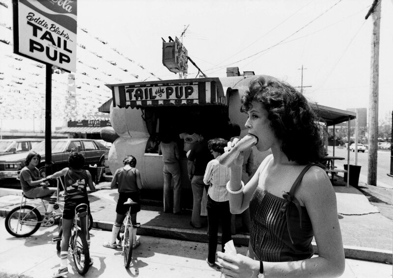 woman eating hot dog at food stand