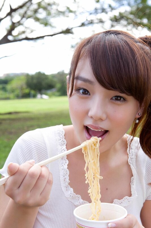 woman eating noodles outdoors