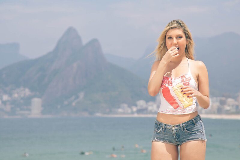 Woman eating on beach with mountains