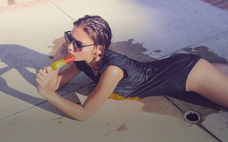 woman eating popsicle on ground
