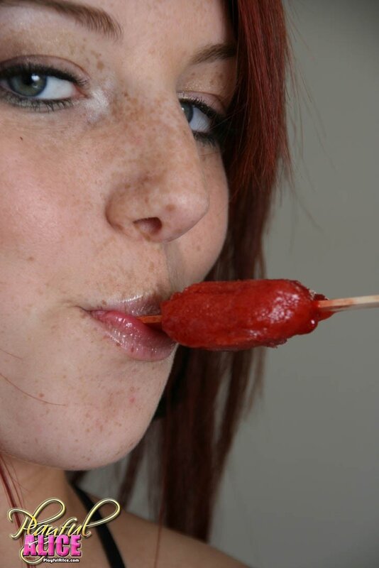 woman eating red candy on stick