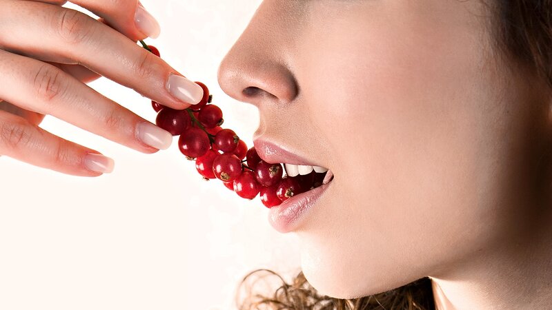 woman eating red currants