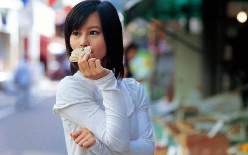 woman eating snack on street