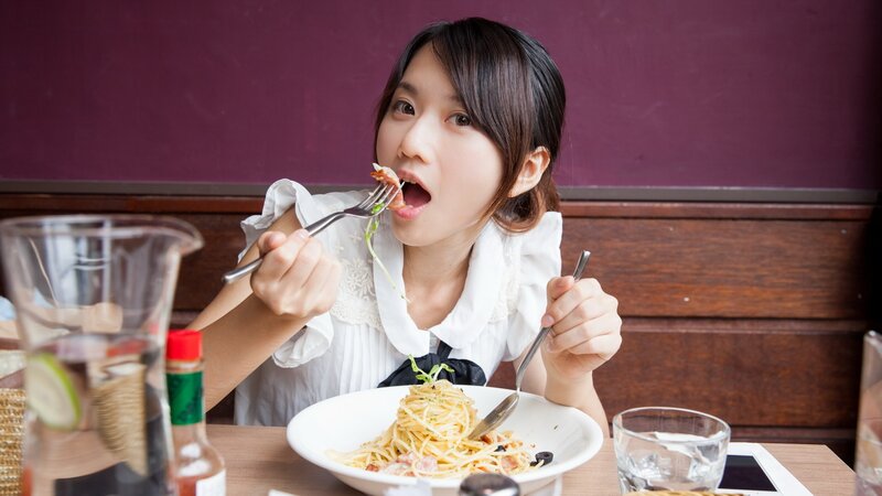 woman eating spaghetti at a restaurant