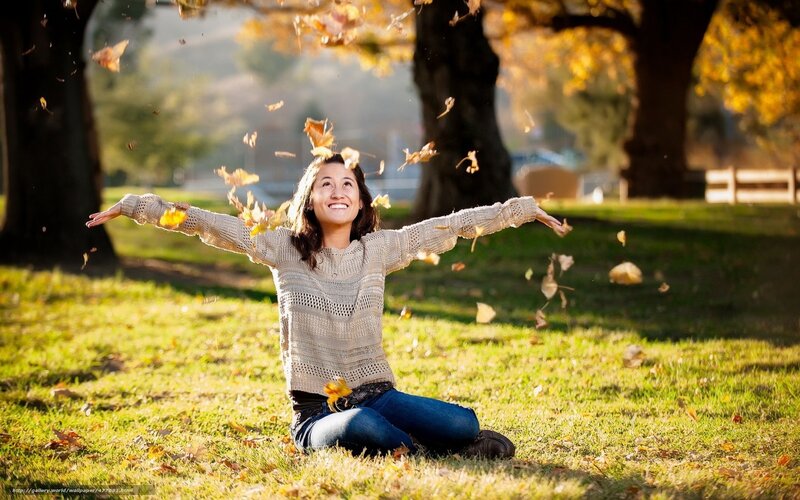 Woman enjoying autumn leaves